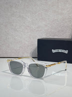 Glasses with clear frame, green-tinted lenses, gold-tone metal accents