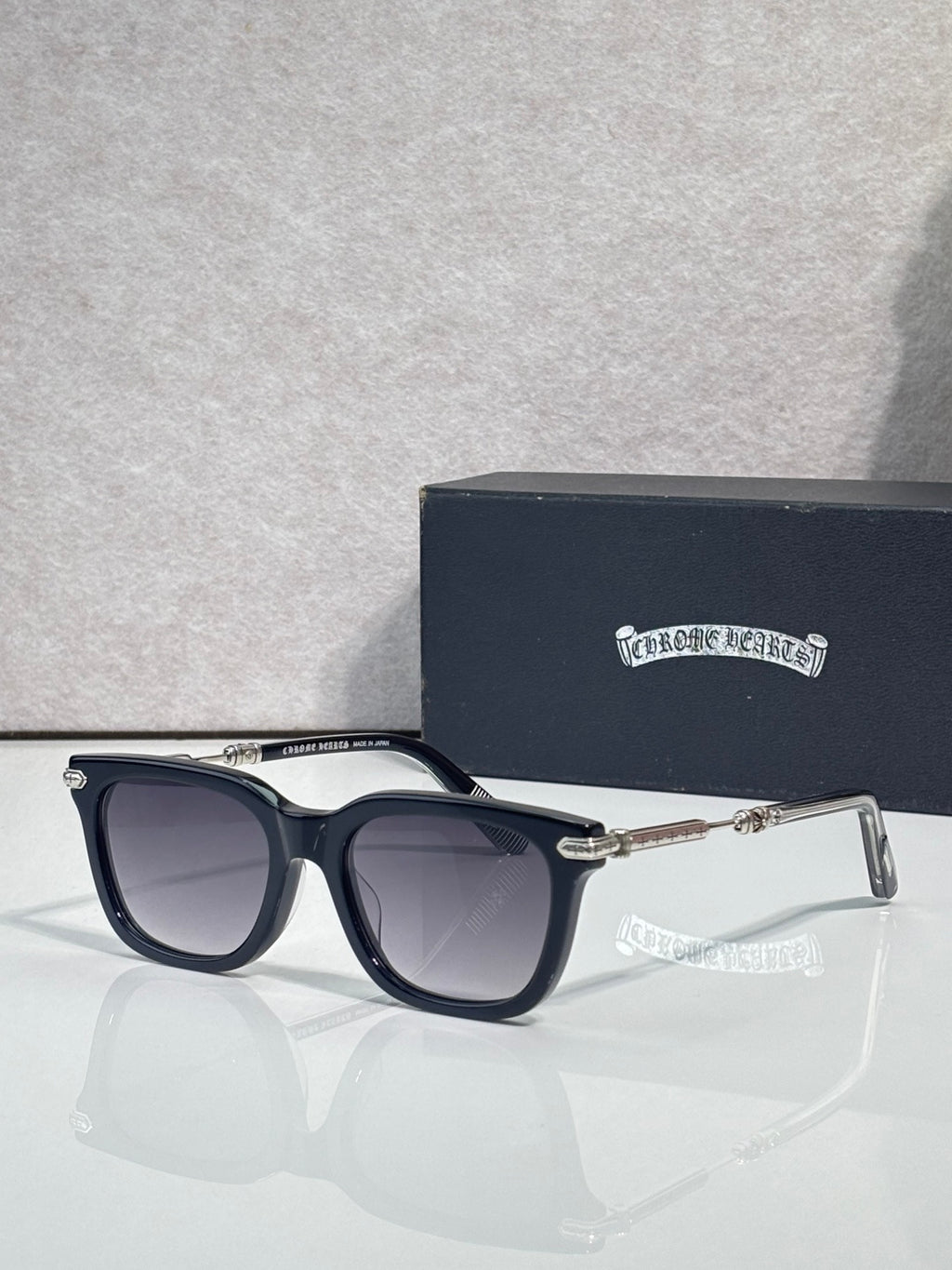 Glasses with dark frame, purple-gray lenses, gold-tone detailing