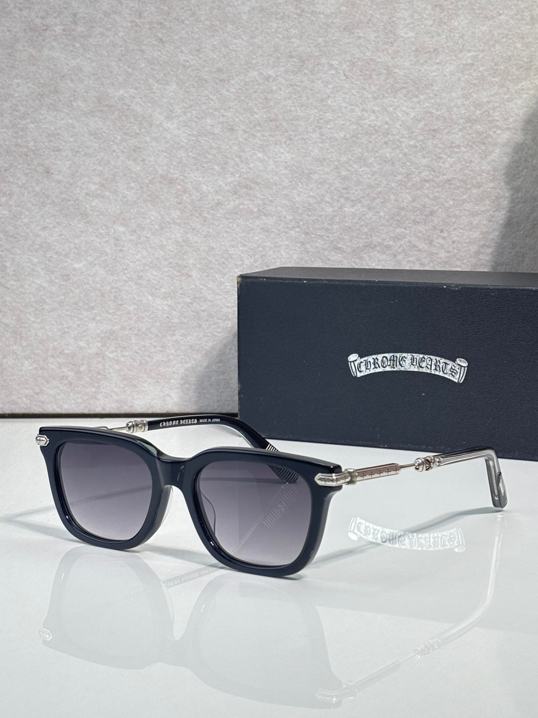 Glasses with dark frame, purple-gray lenses, gold-tone detailing