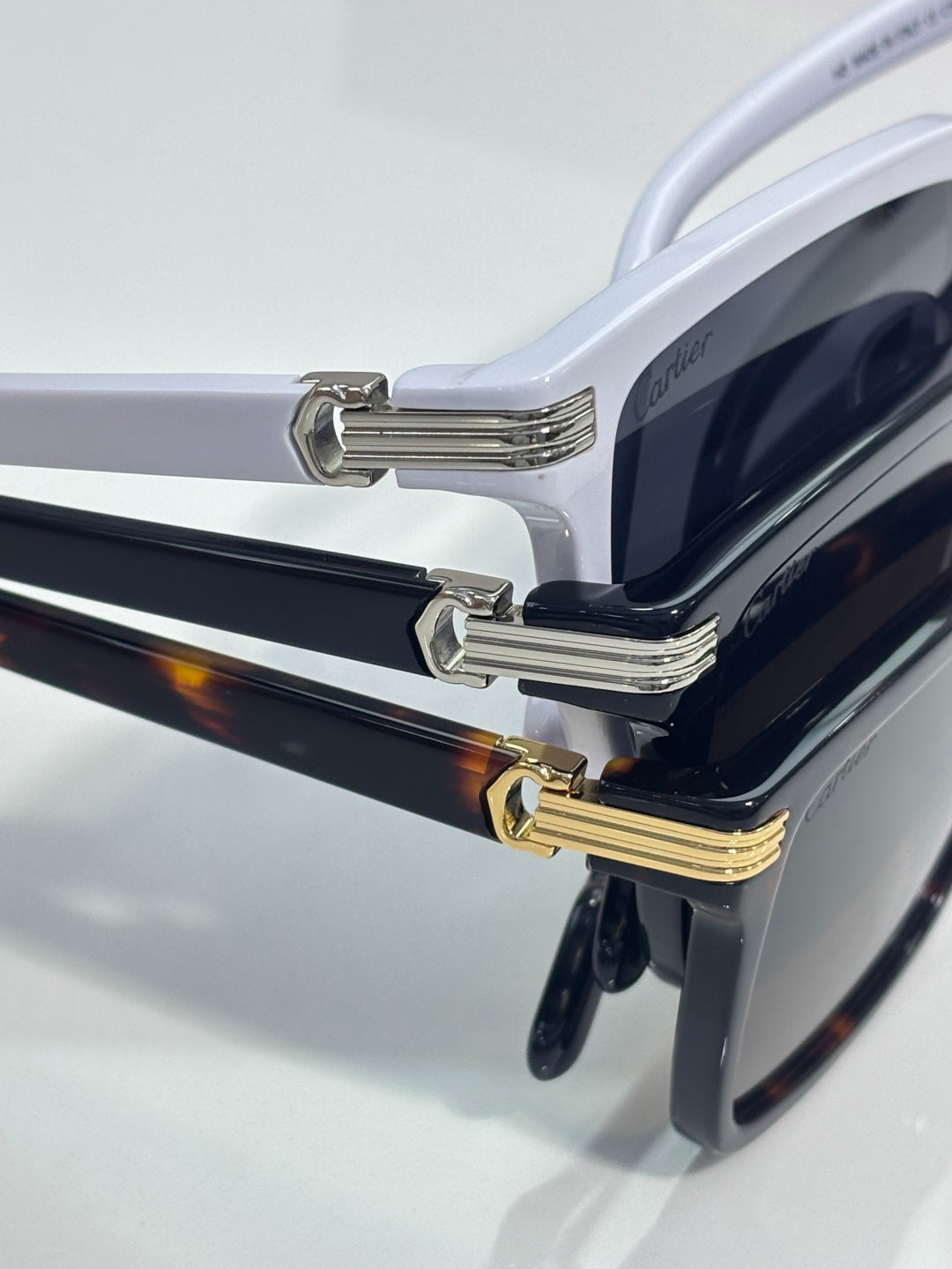 Sunglasses temple and hinge close-up with gold-tone accents and dark lenses