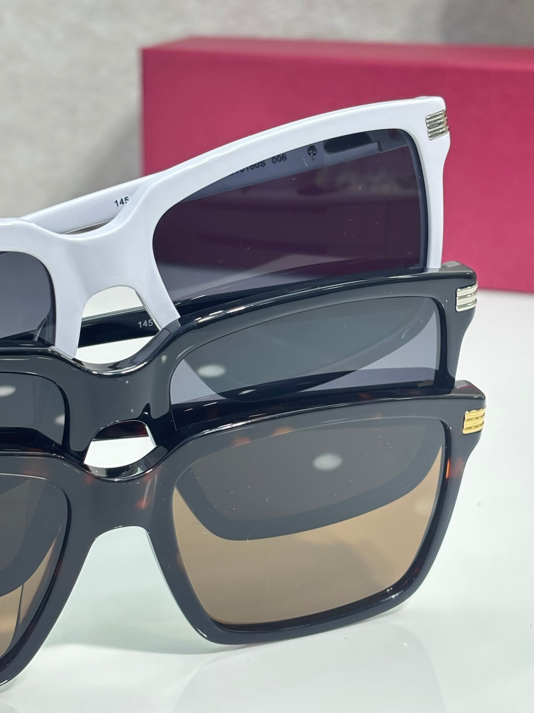 White and dark square sunglasses side view with tinted lenses and gold detail