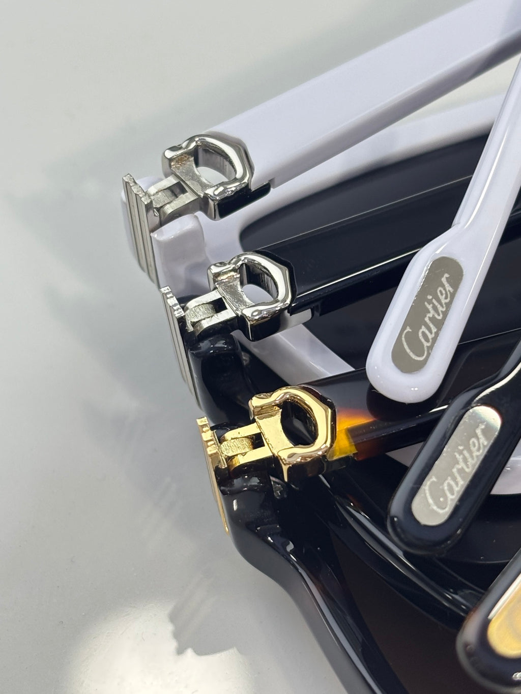 Sunglasses hinge close-up with gold and silver-tone hardware on the frame