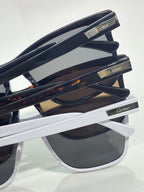 Sunglasses side close-up with dark temples and gold logo labels on the arms