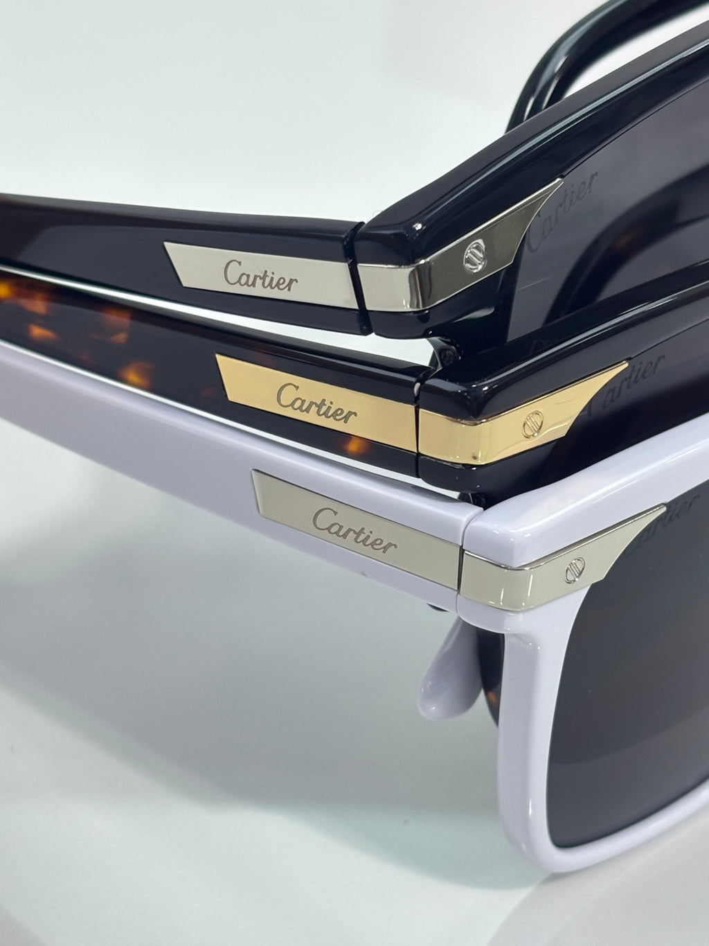 Sunglasses side view with dark glossy temples and gold Cartier logo accents
