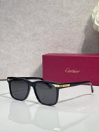 Sunglasses with dark frames, blue-tinged lenses, and gold hinge detail