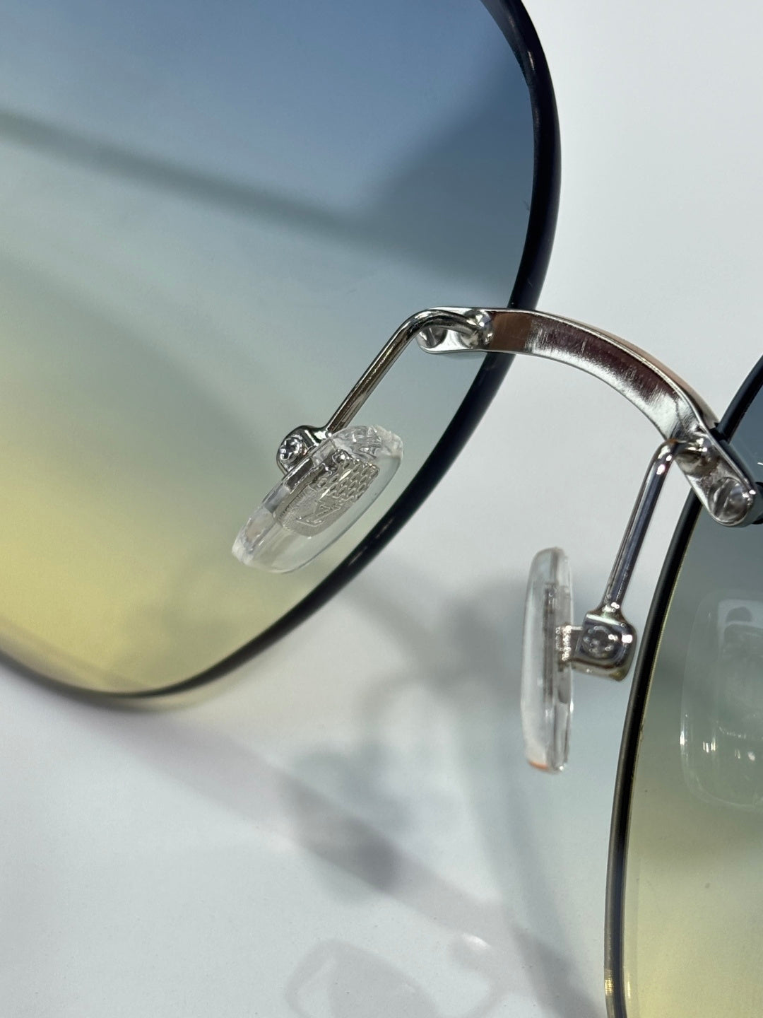 Louis Vuitton glasses close-up of silver hinge and clear lens edge with metal arm