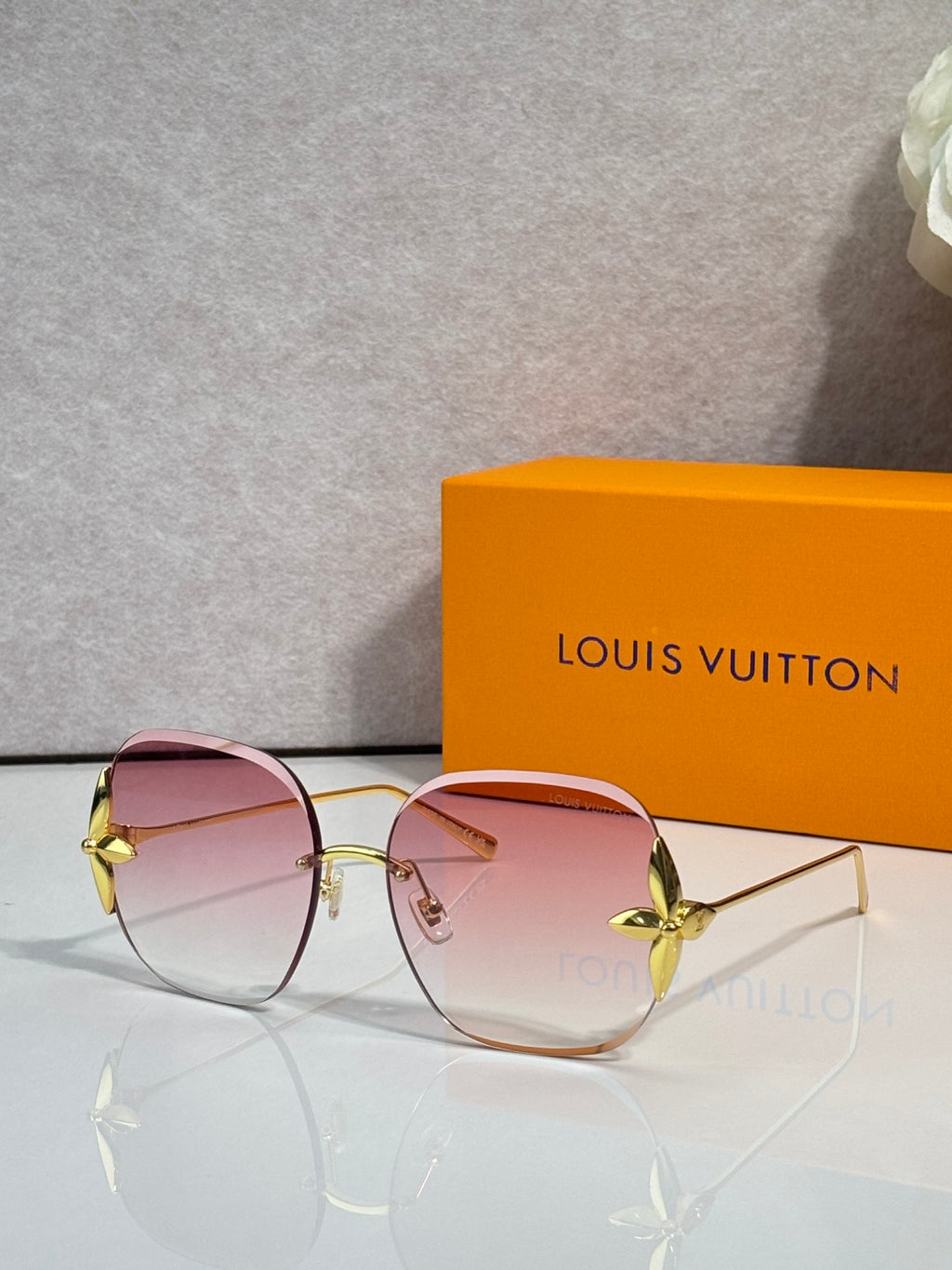 Louis Vuitton glasses with round pink-tinted lenses, gold frame and hinged temple detail