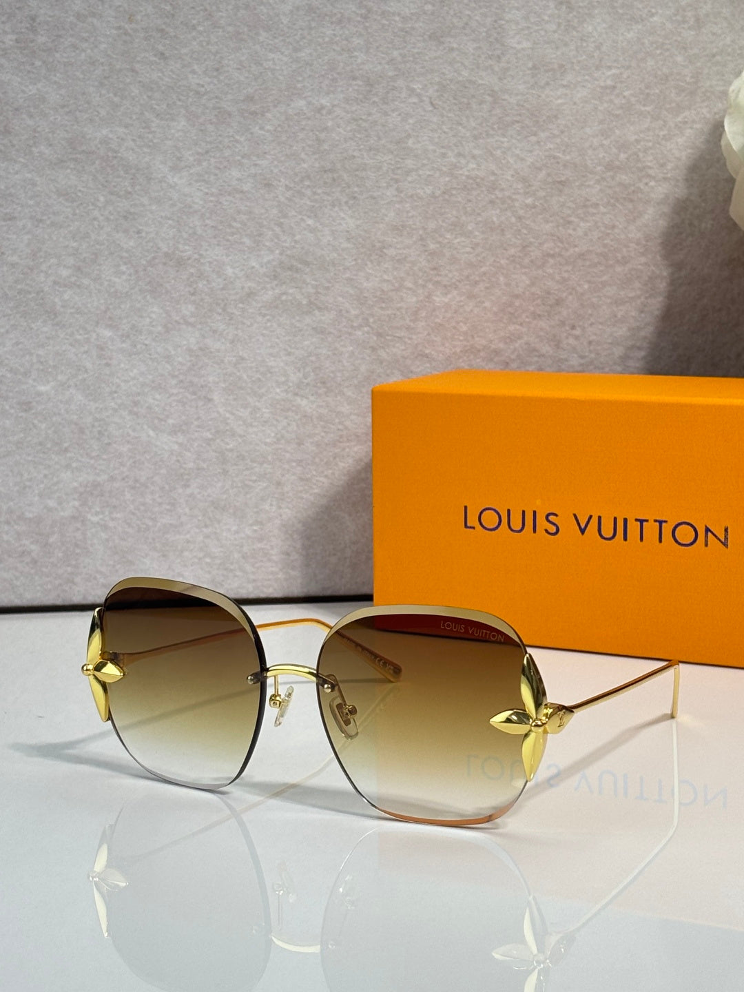 Louis Vuitton glasses with round amber-tinted lenses, gold frame and curved temple tips