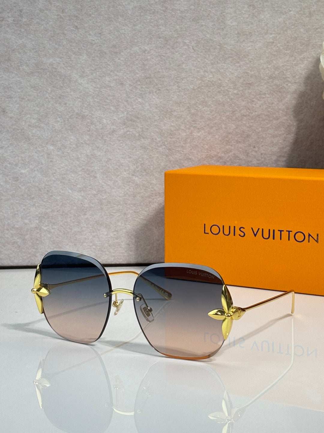 Louis Vuitton glasses with round blue-tinted lenses, gold frame and curved metal arms