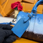 Blue monogram handbag detail with front strap, buckle hardware, and smooth leather panel.