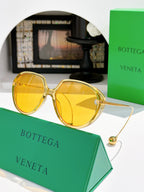 Bottega Veneta sunglasses with round tortoise frame and yellow lenses, gold accents.