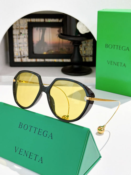 Bottega Veneta sunglasses with dark tortoise frame and yellow mirrored lenses, gold arms.