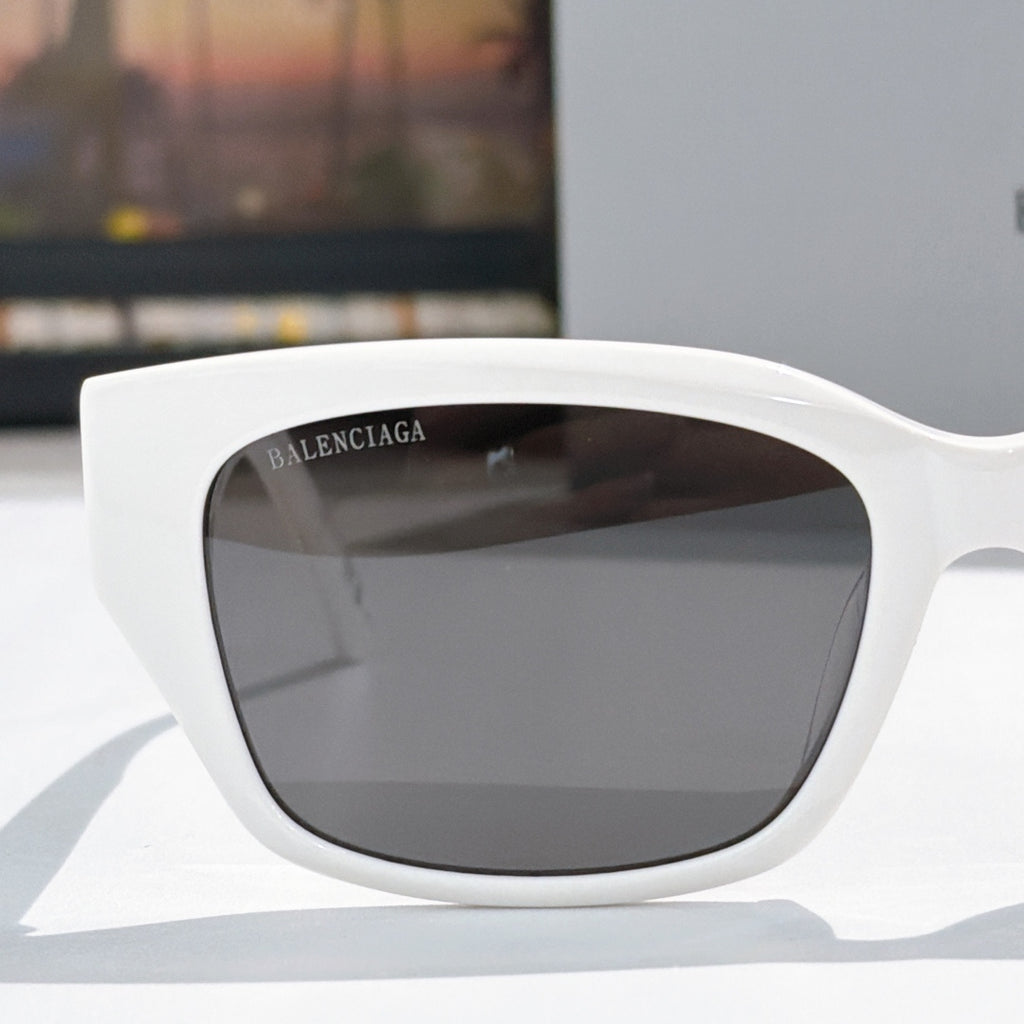 Balenciaga white sunglasses with dark tinted lenses, rounded cat-eye profile