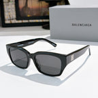 Balenciaga sunglasses with black frames and dark tinted lenses, wide cat-eye silhouette