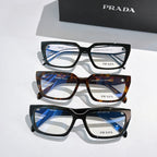 Three pairs of Prada eyeglasses with black and tortoiseshell frames and clear lenses