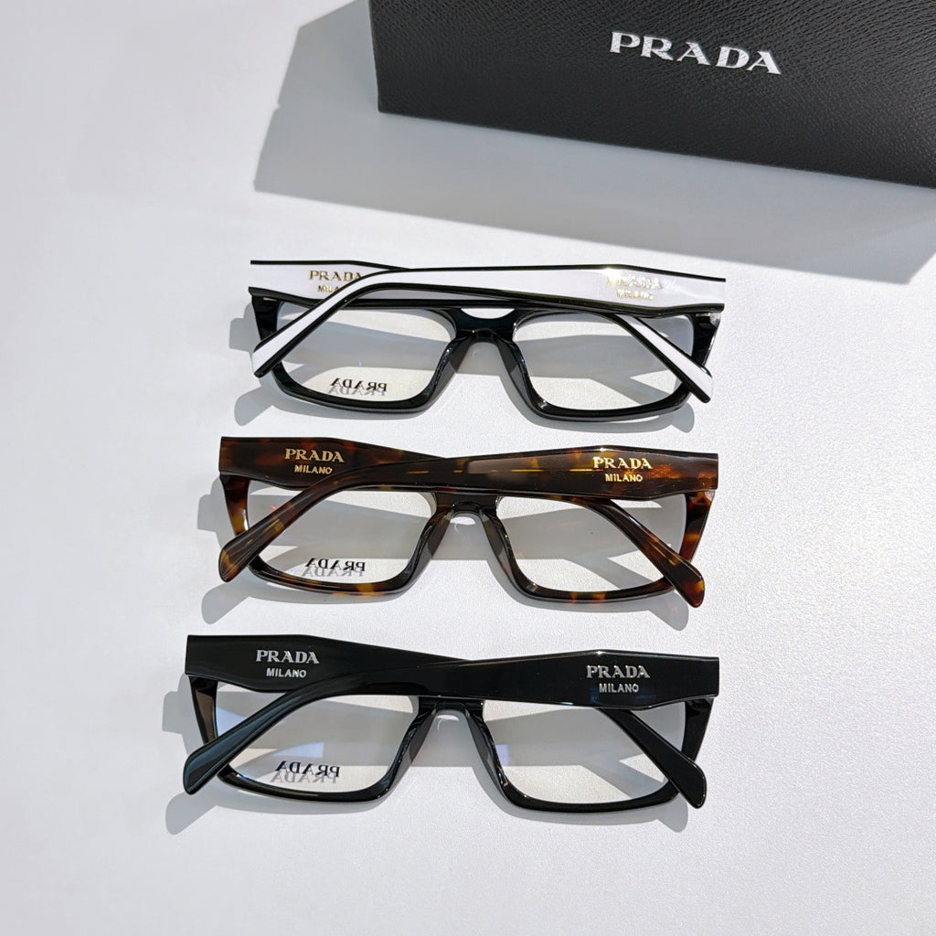 Three pairs of Prada eyeglasses with black and tortoiseshell full-rim frames and clear lenses