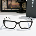Prada eyeglasses with black full-rim frame and clear lenses, rectangular rounded shape