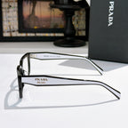 Prada eyeglasses with black metal temples and clear lenses, side profile