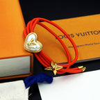 Louis Vuitton red cord bracelet with gold heart charm and gold bow charm