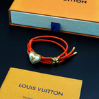 Louis Vuitton red cord bracelet with gold heart charm and gold bow centerpiece
