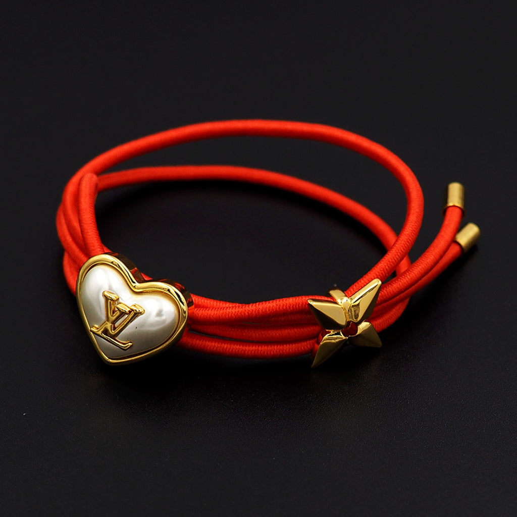 Louis Vuitton red cord bracelet with gold heart charm and gold bow charm