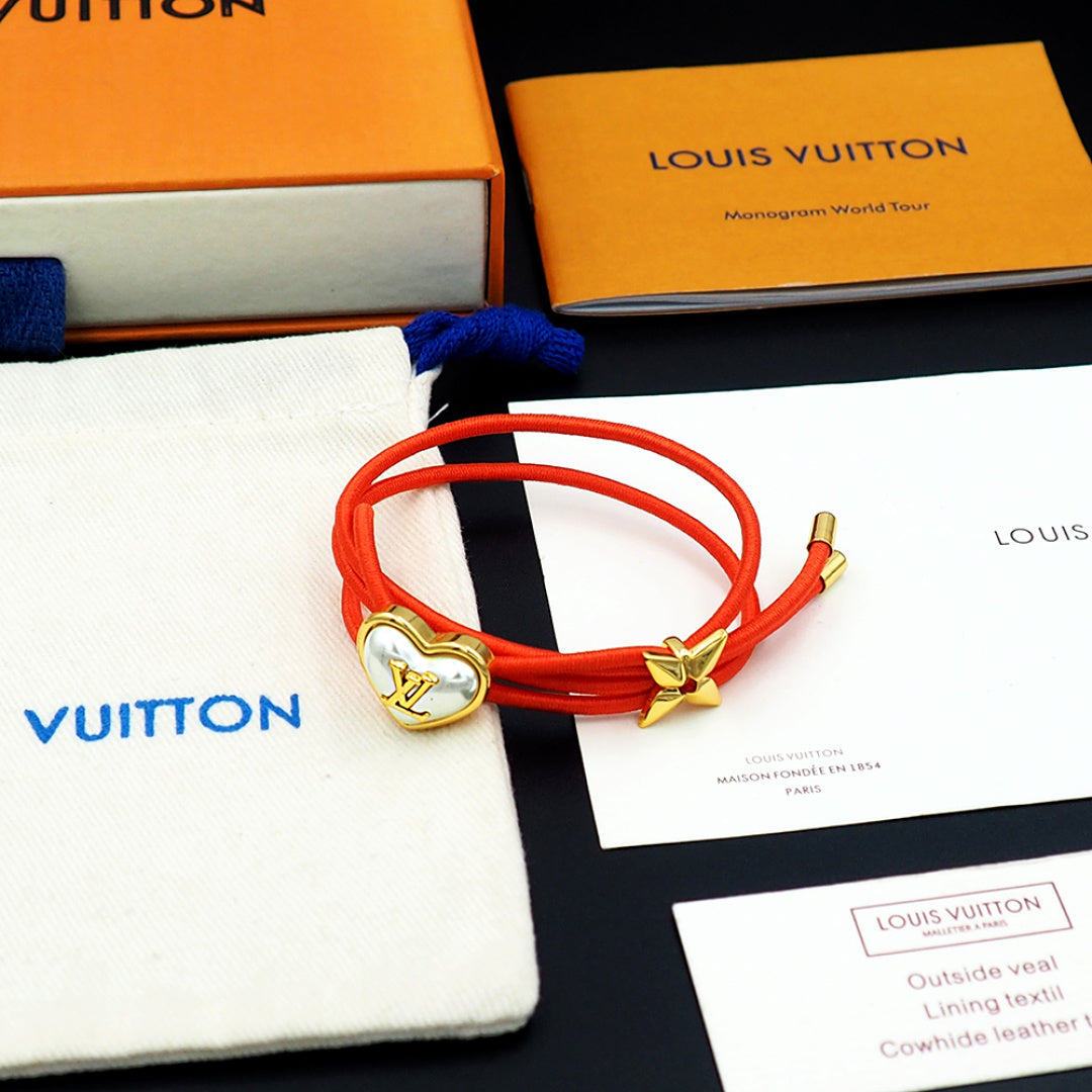 Louis Vuitton red cord bracelet with gold heart charm and bow accent