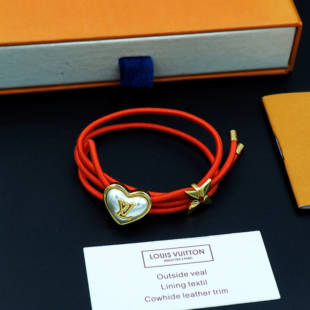 Louis Vuitton red cord bracelet with gold heart charm and gold bow charm