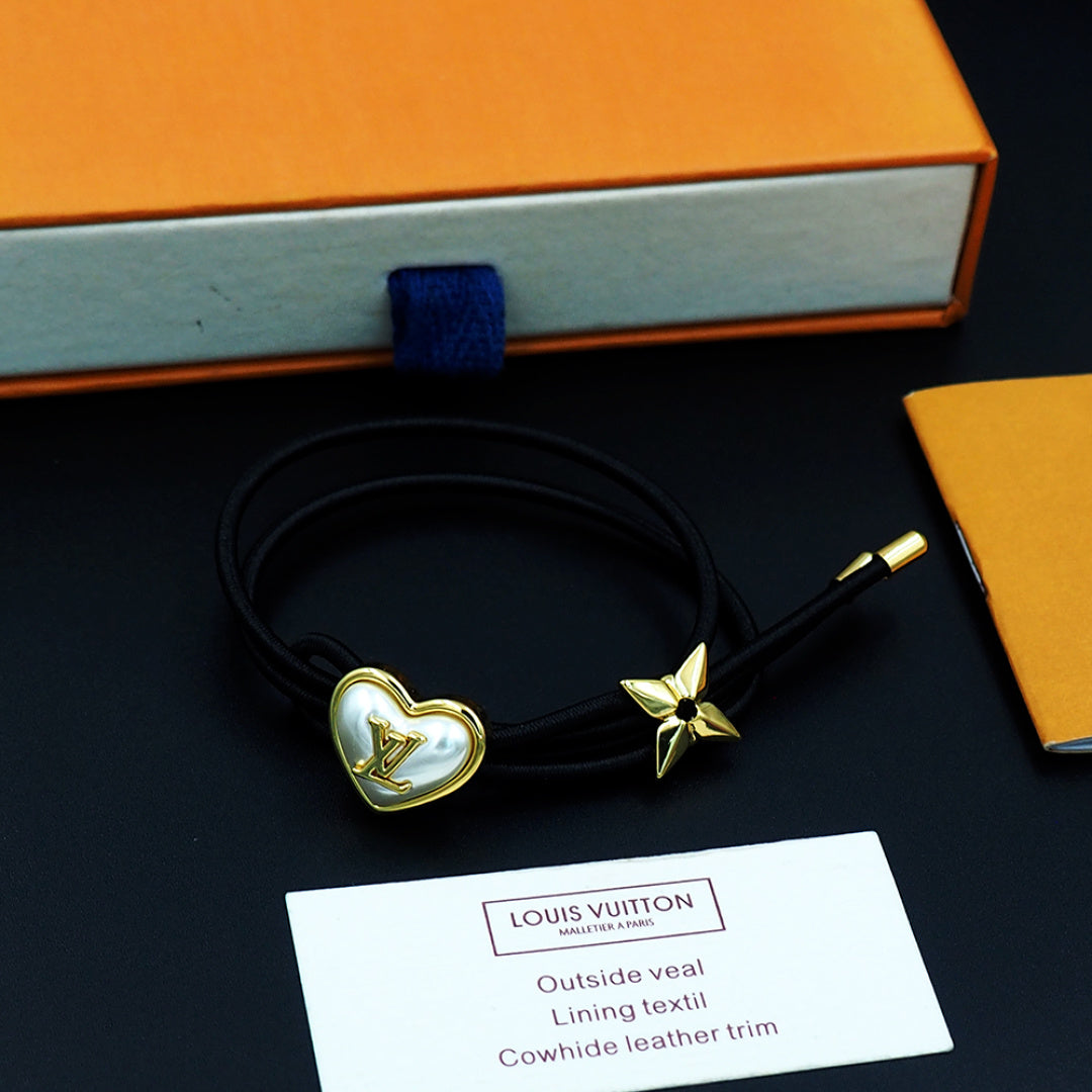 Black cord bracelet with gold heart charm and gold star accent