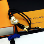 Black cord bracelet with gold heart charm and gold star charm on display