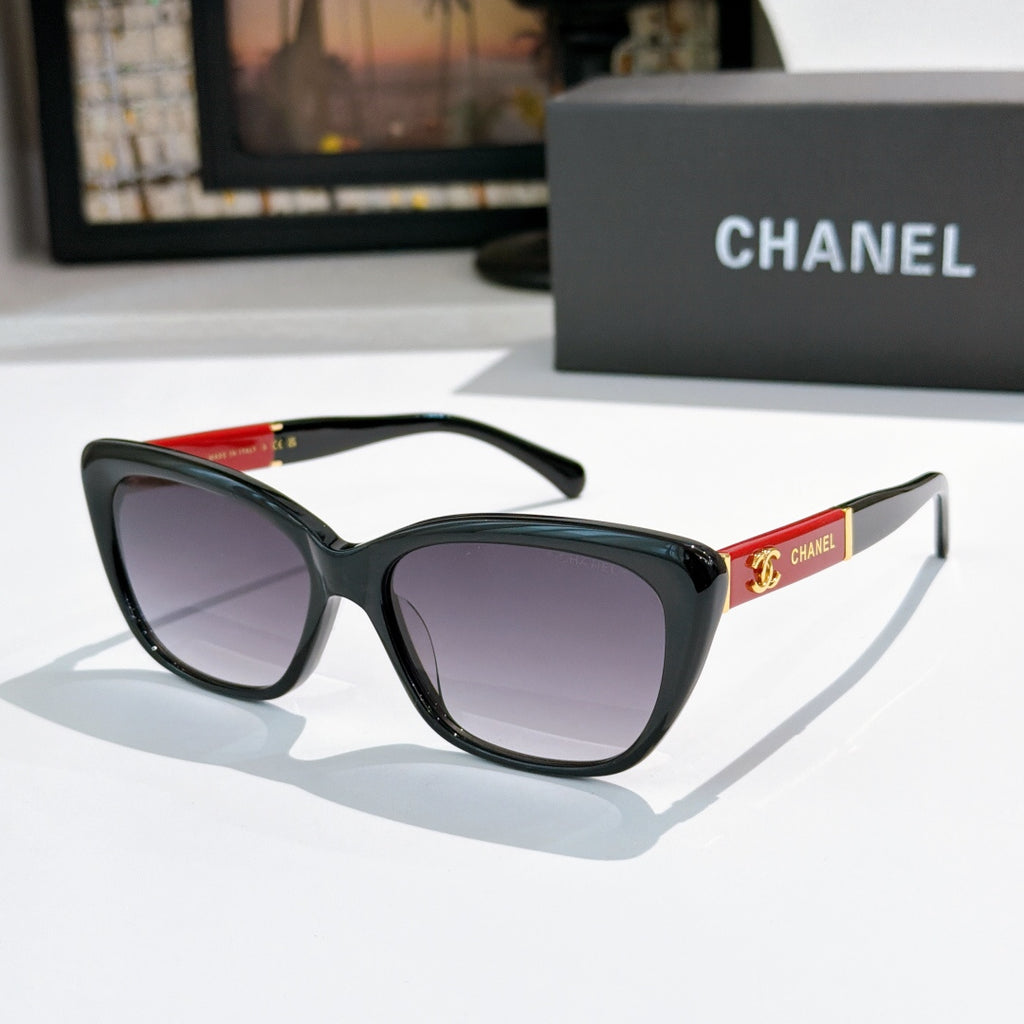 Black cat-eye sunglasses with dark lenses and red temple detail