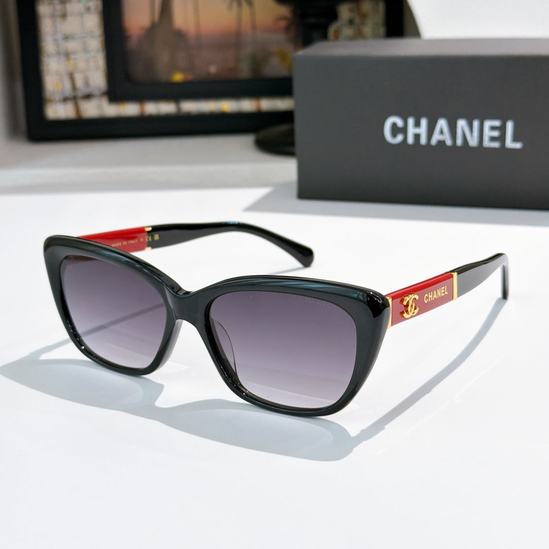 Black cat-eye sunglasses with dark lenses and red temple detail