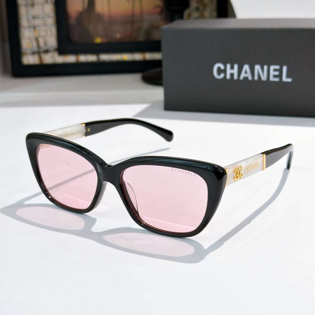 Black cat-eye sunglasses with pink-tinted lenses and gold Chanel logo on temple