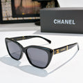 Black cat-eye sunglasses with dark lenses and gold Chanel logo on temple