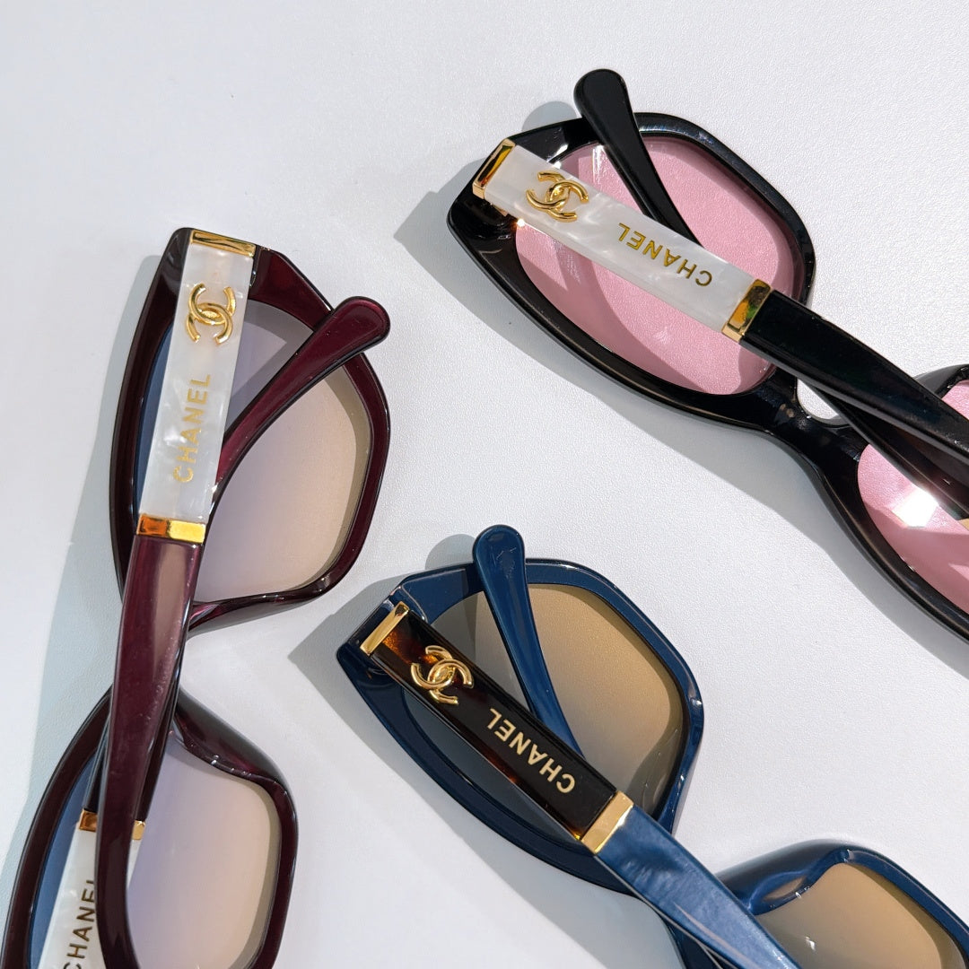 Chanel sunglasses close-up, maroon and black/pink frames, plus blue pair