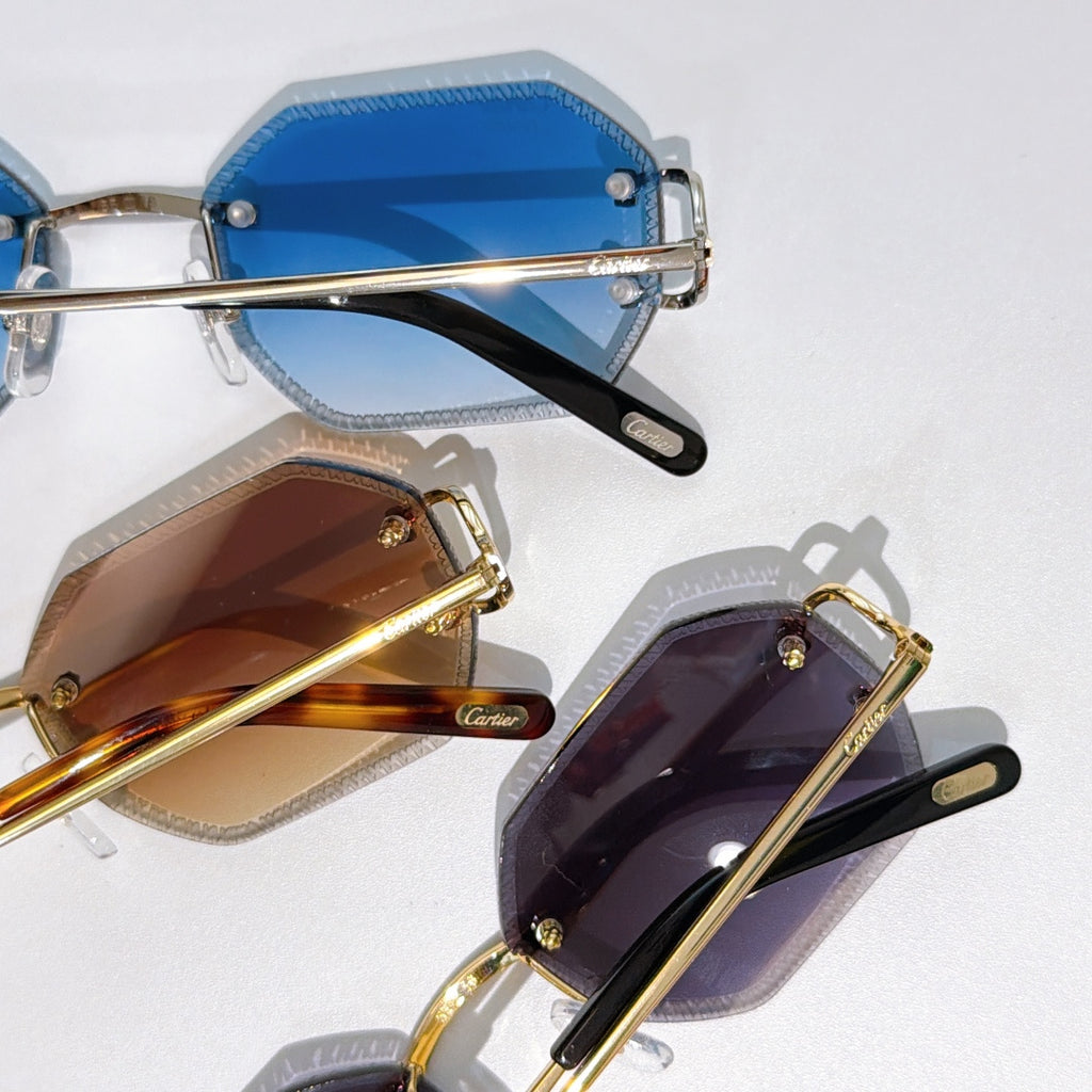 Stacked Cartier sunglasses with blue, brown, and purple tinted lenses, gold frames