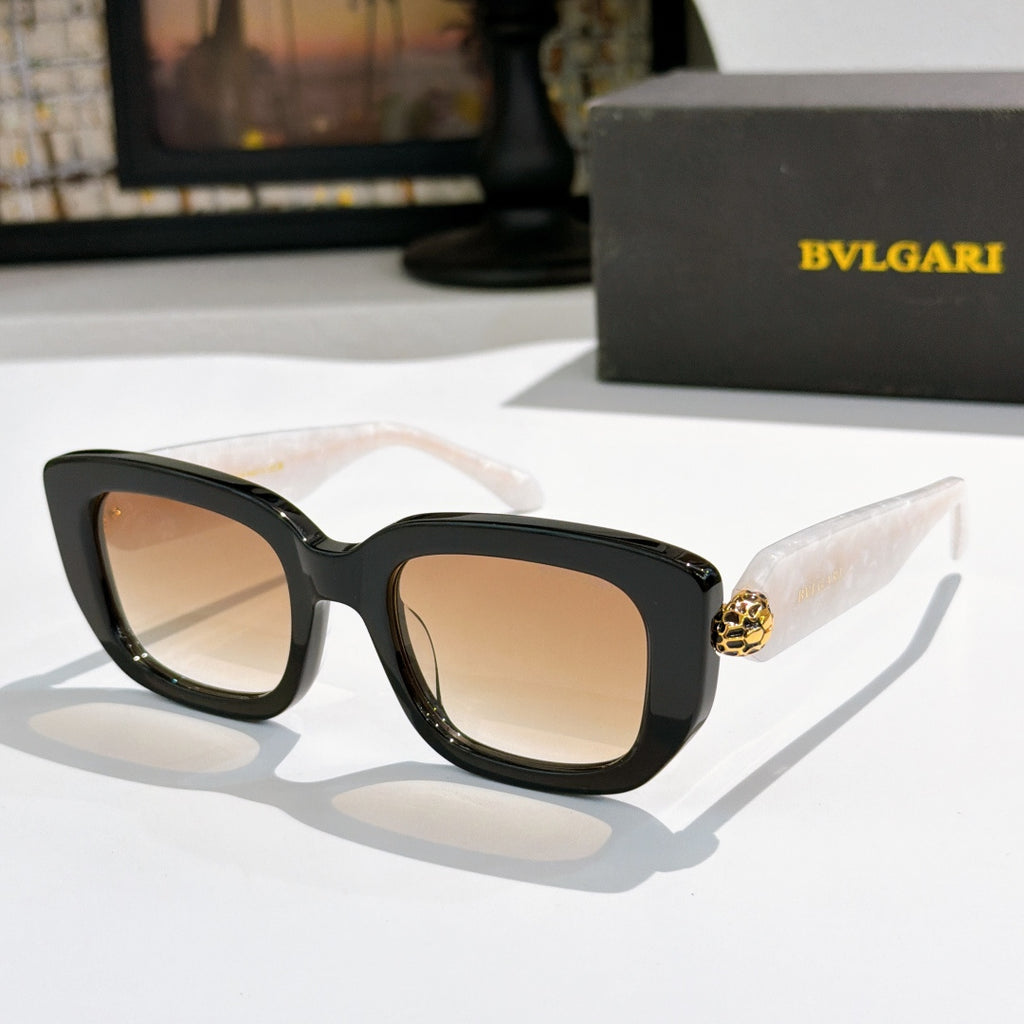 Black cat-eye sunglasses with nude-pink lenses and gold logo bridge detail.
