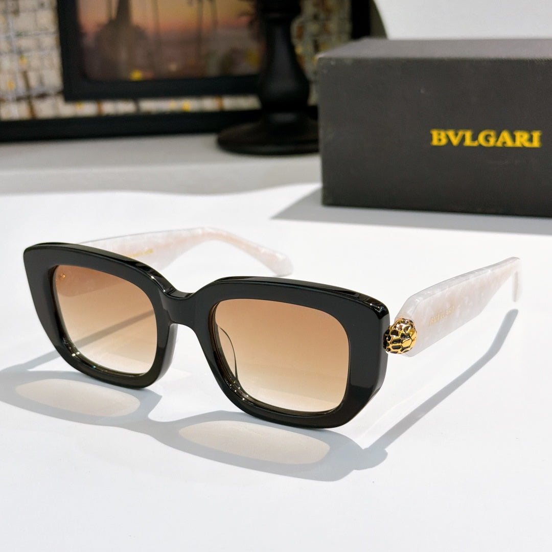 Black cat-eye sunglasses with nude-pink lenses and gold logo bridge detail.