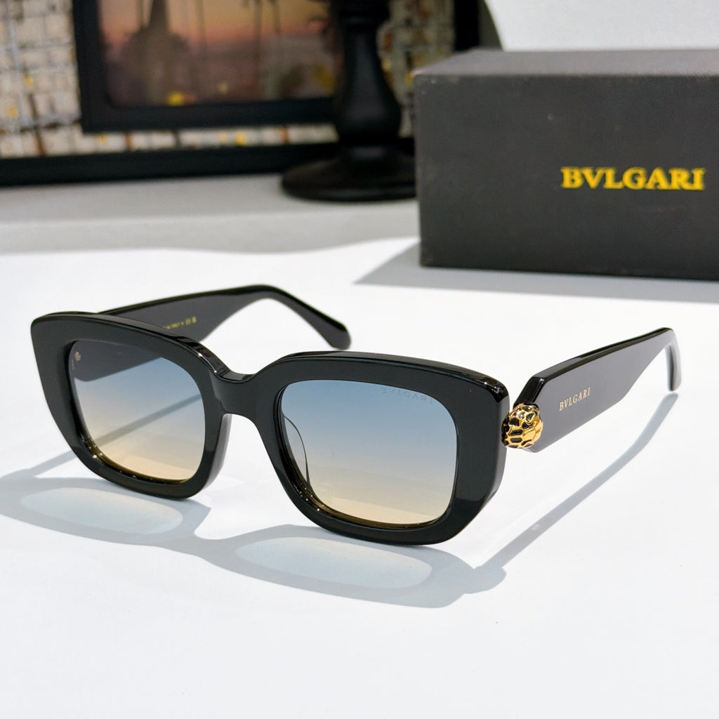 Black cat-eye sunglasses with light amber lenses and gold logo bridge detail.