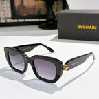 Black cat-eye sunglasses with dark lenses and gold logo accent on the bridge.