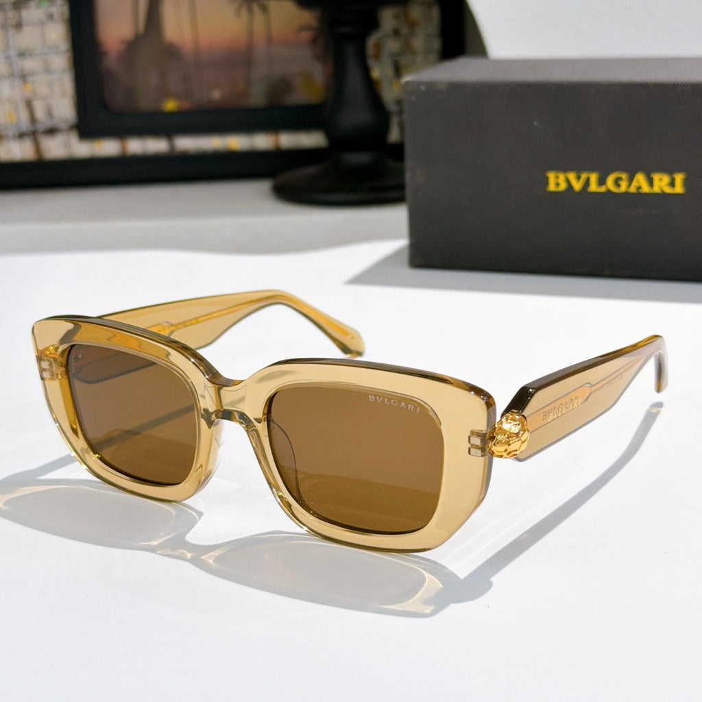 Gold cat-eye sunglasses with brown lenses and gold logo bridge detail.