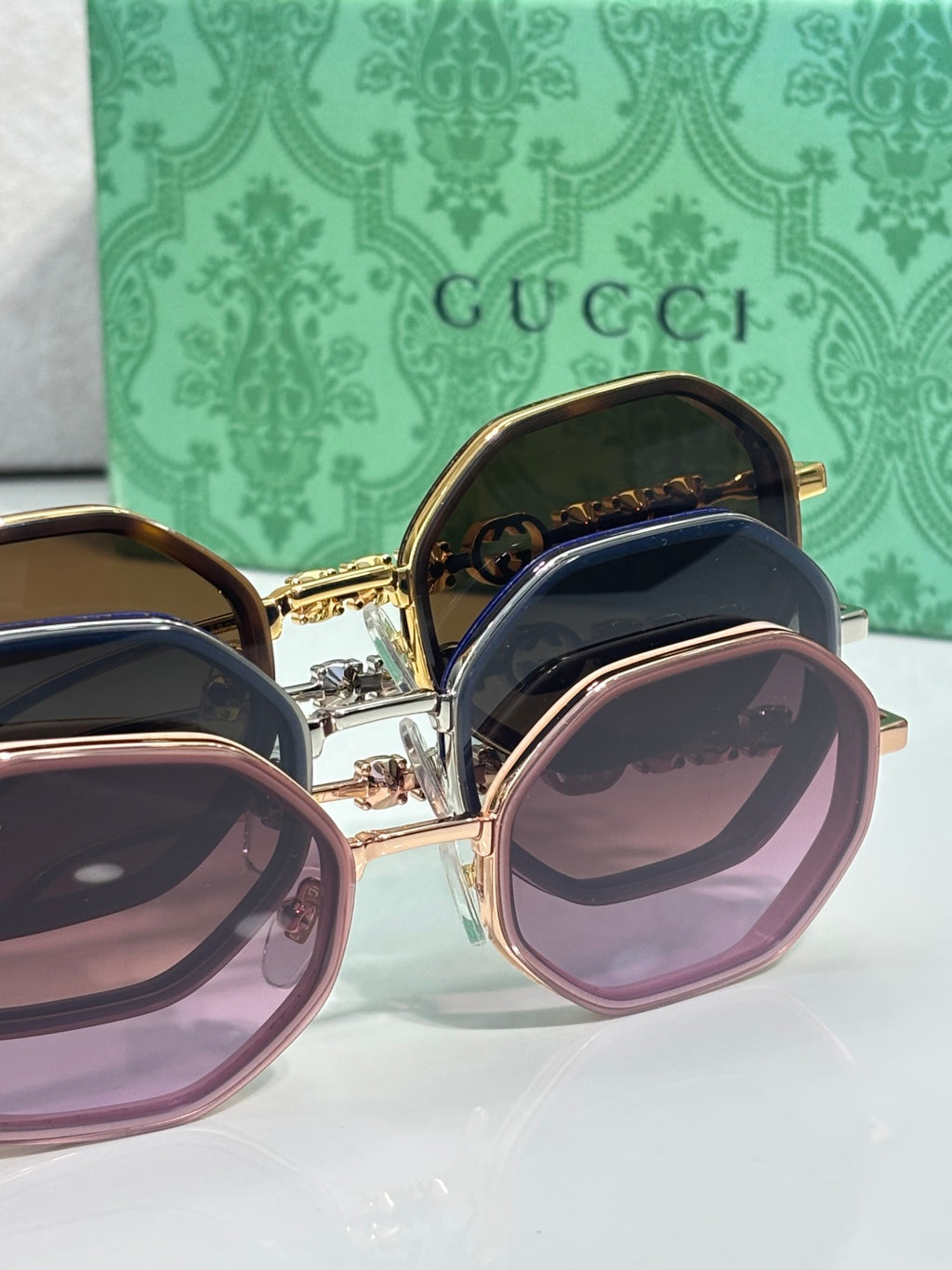 Gucci sunglasses set, round frames with purple and brown lenses in gold-tone.