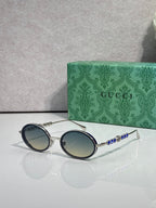Gucci round sunglasses with silver-tone frame and blue gradient lenses.