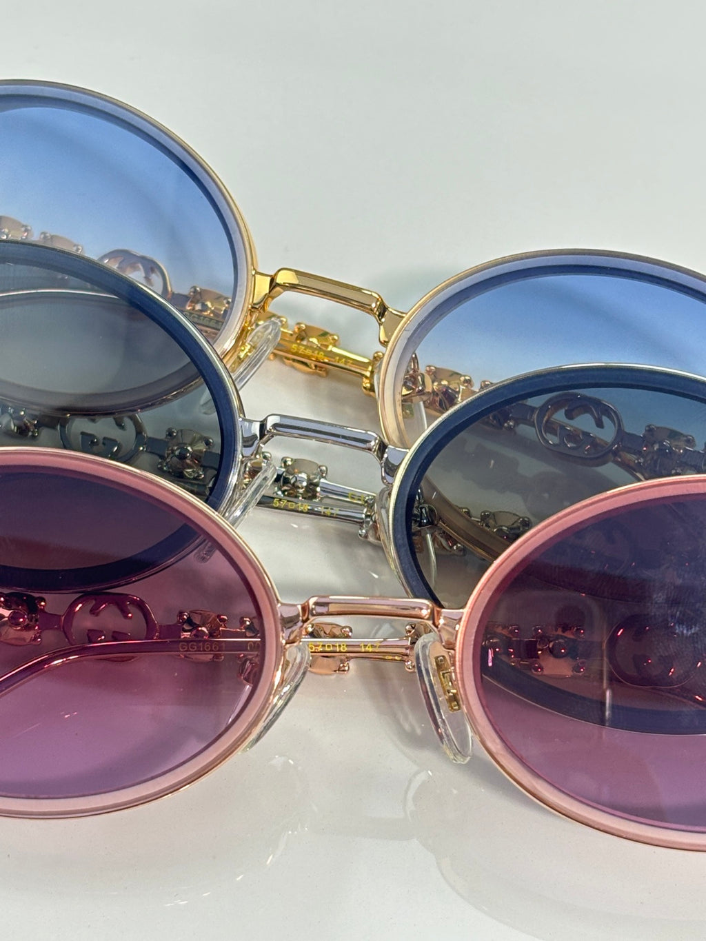 Gucci round sunglasses close-up with blue and pink lenses in gold and silver frames.