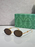 Gucci round sunglasses with gold-tone frame and dark brown lenses.