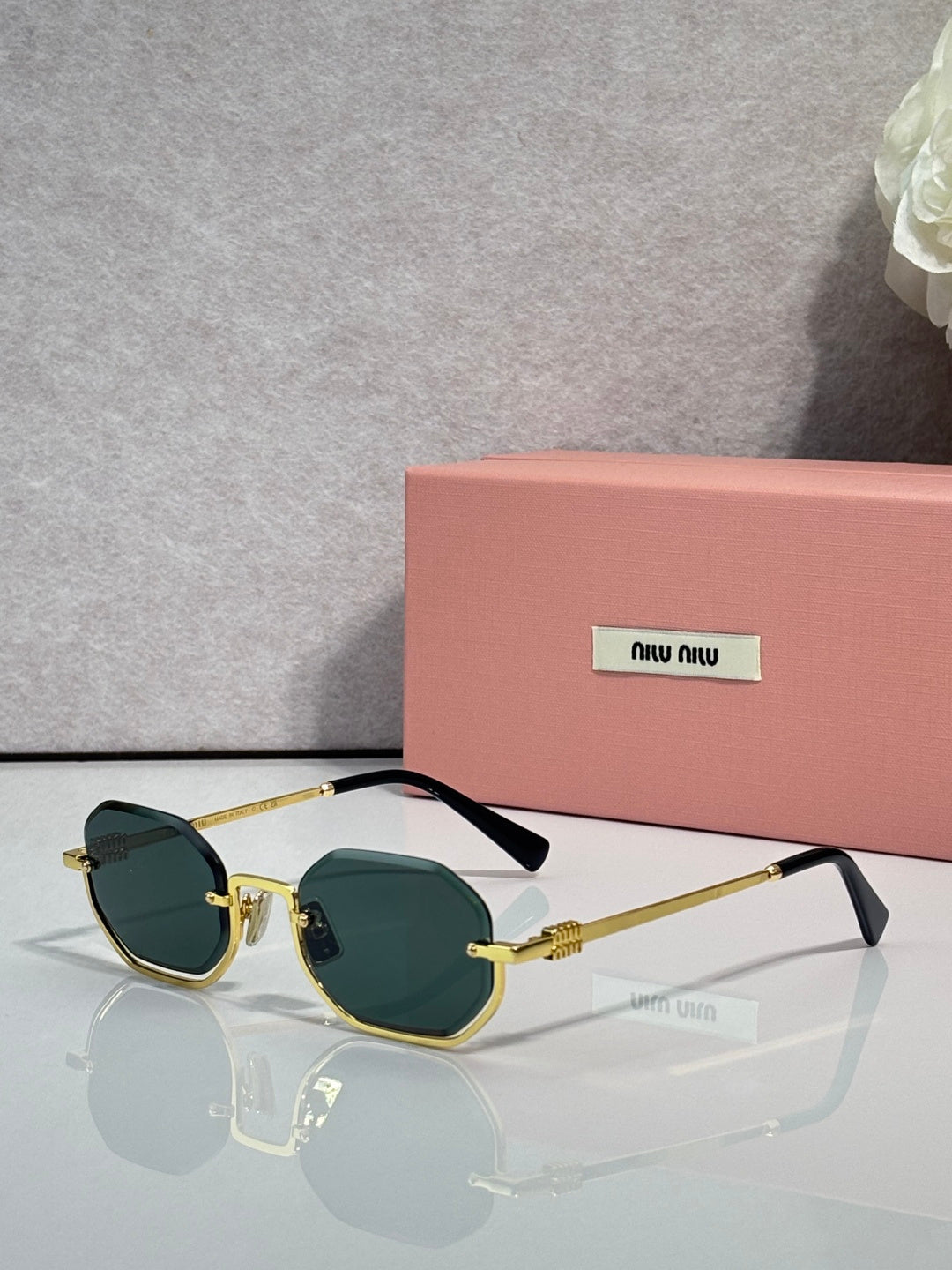MiuMiu sunglasses with gold frame, green tinted lenses, rounded butterfly shape