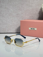 MiuMiu sunglasses with gold frame, blue tinted lenses, rounded butterfly shape