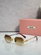 MiuMiu sunglasses with gold frame, light brown tinted lenses, rounded butterfly shape