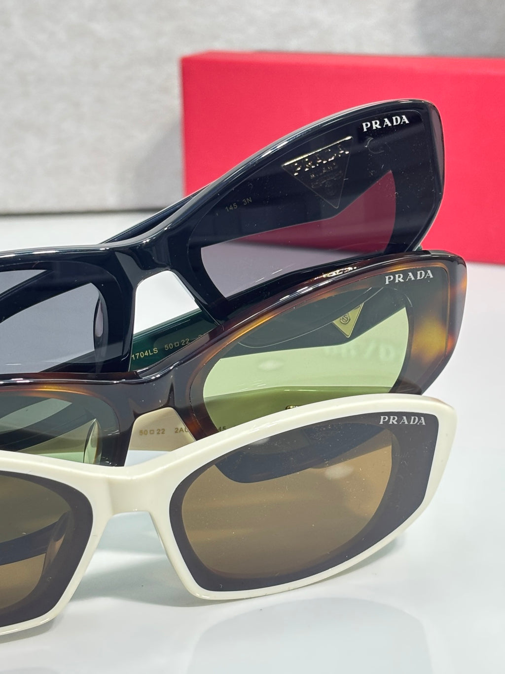 Blue and white cat-eye sunglasses with PRADA logos on frames and lenses