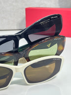Blue and white cat-eye sunglasses with PRADA logos on frames and lenses