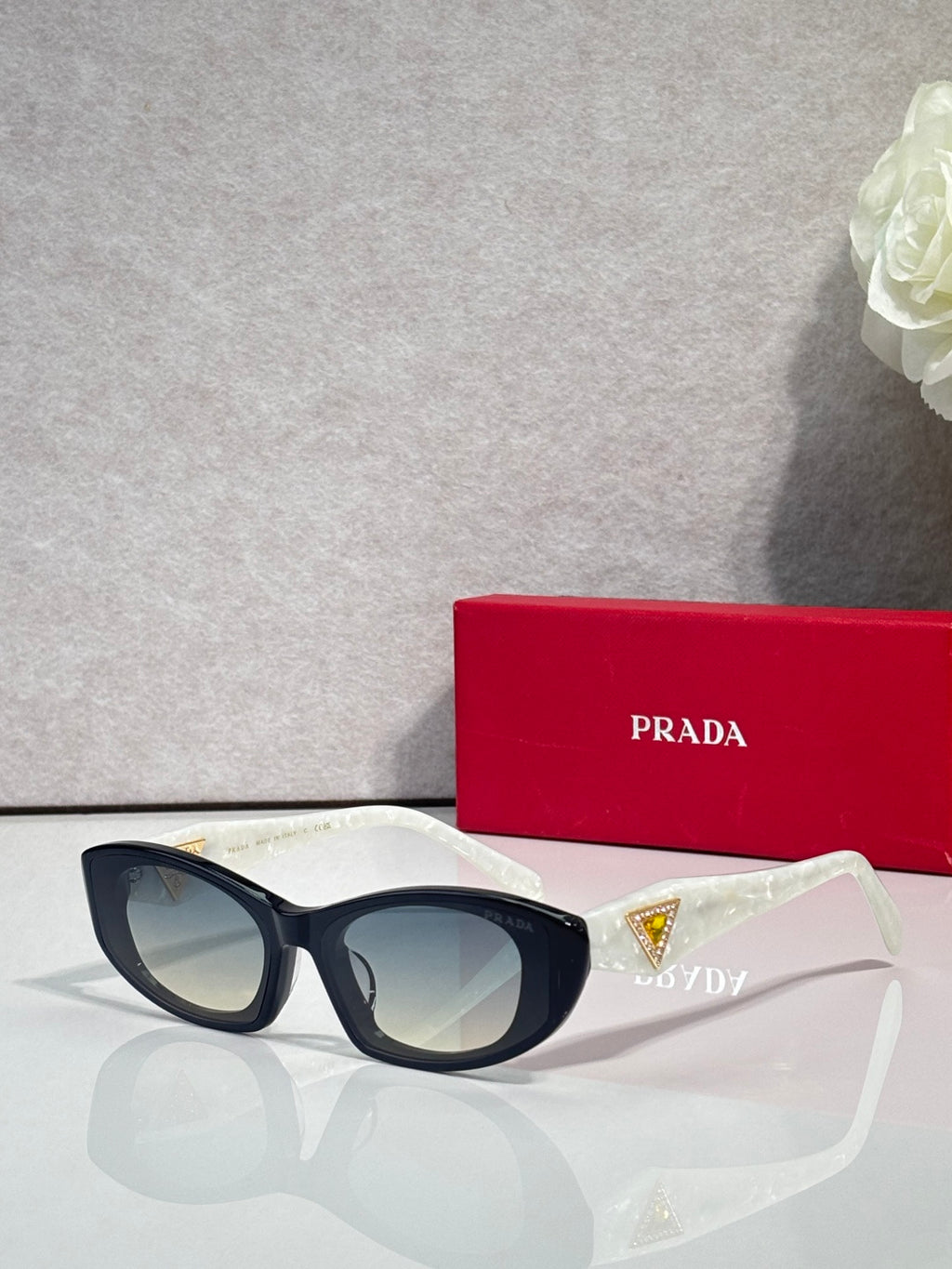 Black cat-eye sunglasses with blue and gold triangular temple accents
